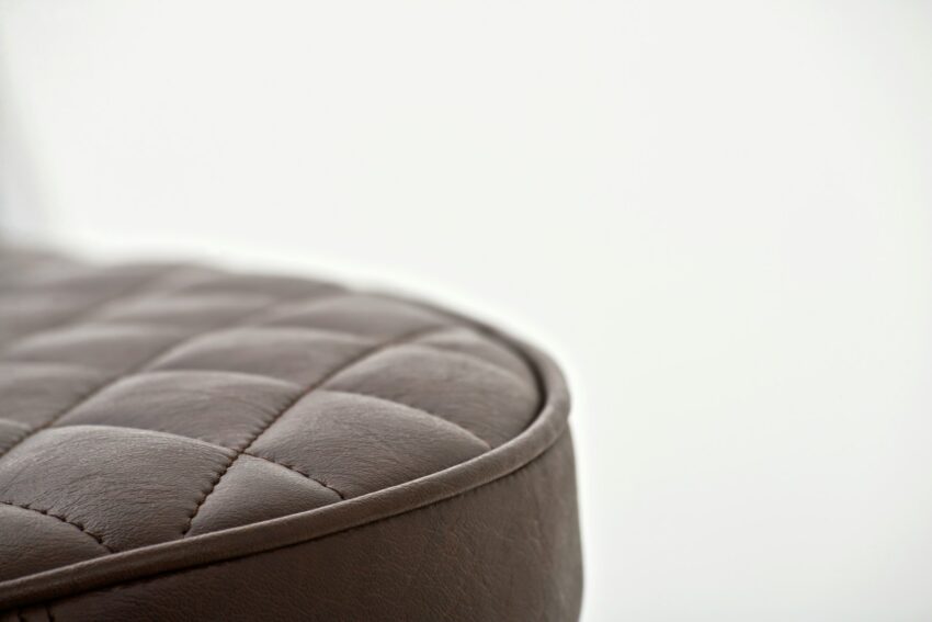 black leather round ottoman on white background